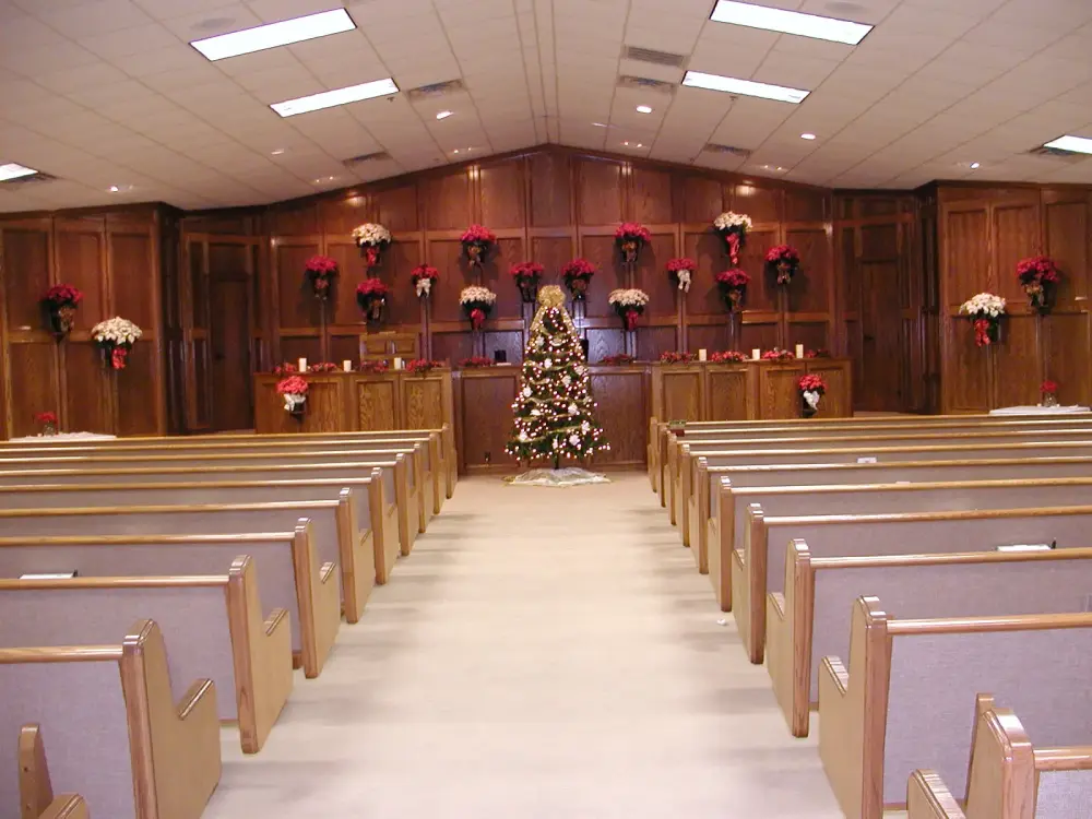 Funeral chapel decorated with a Christmas tree and holiday flowers