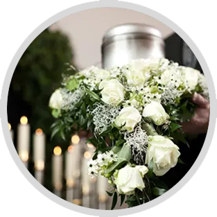 White roses and greenery funeral arrangement